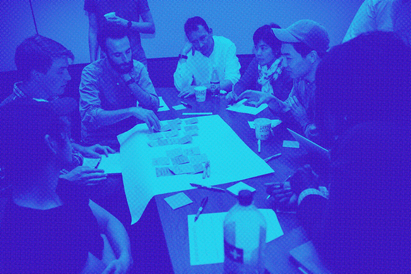 Group of students gather around table with post-its and paper